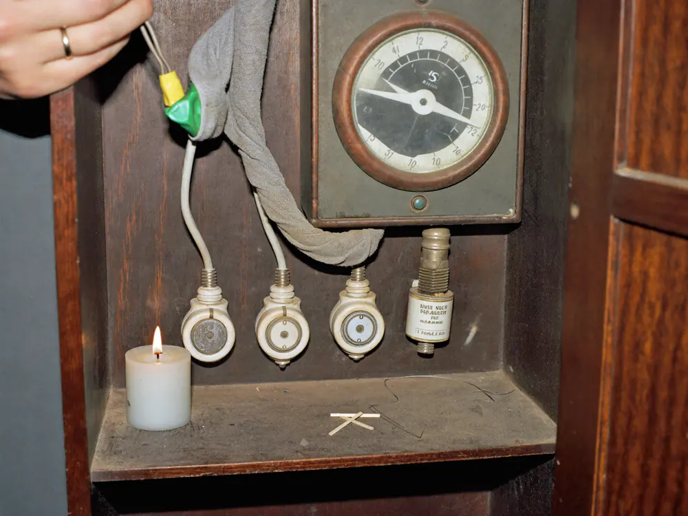 Oude meterkast met schroefzekeringen op een houten bord, vlak voor de vervanging